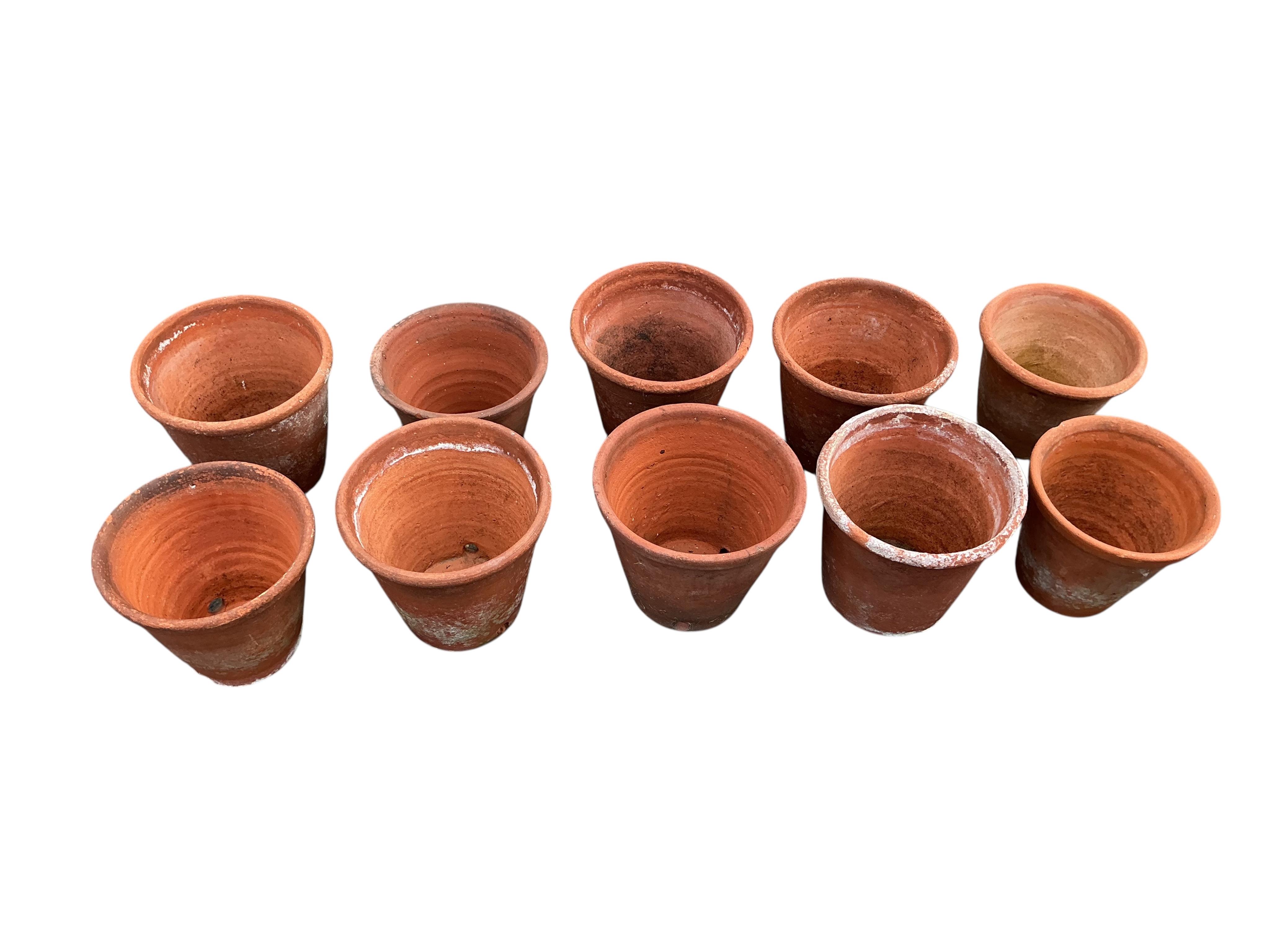 A set of ten terracotta garden planters, largest diameter 24cm, height 22cm